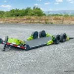 Blurred Background focusing on the high quality 22 foot FlatTrak Charcoal and Lime Green Equipment no ramps low clearance trailer 14k